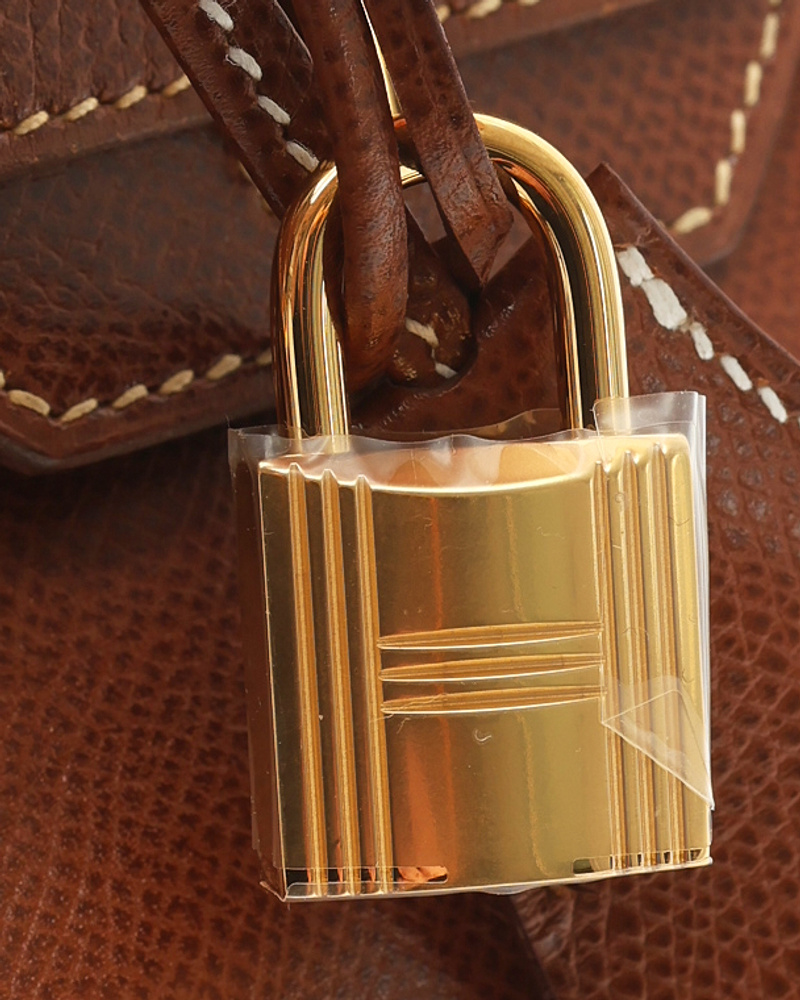 Close-up of the gold-toned padlock on the brown Hermès Birkin 30 Courchevel Bag, highlighting the hardware and leather texture.