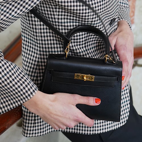 Birkin bag in Hermes orange on a cream white sofa