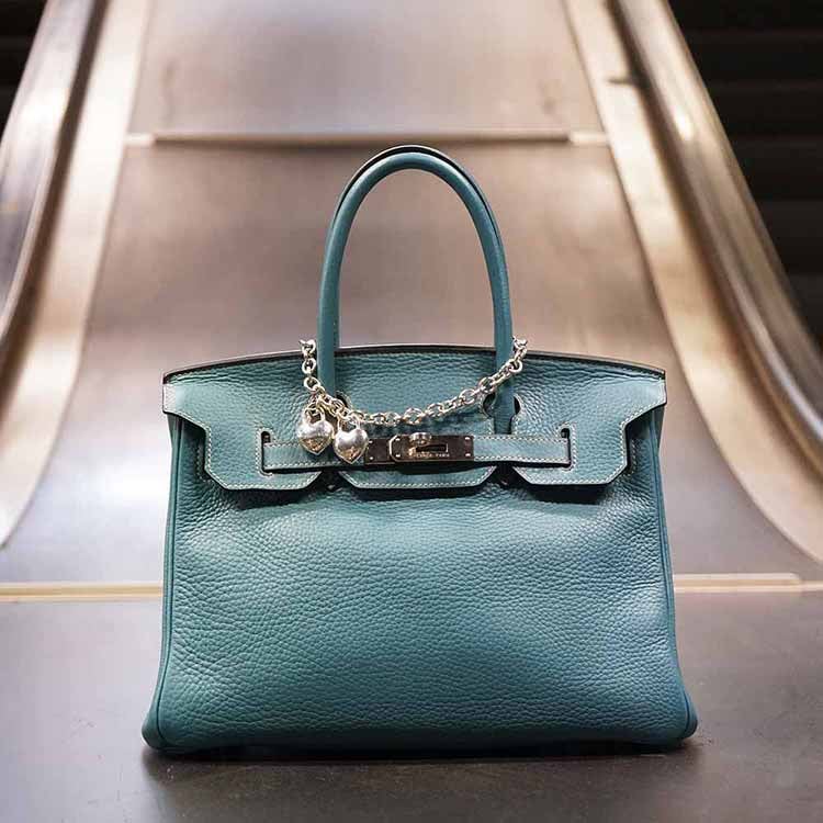 Birkin bag in Hermes orange on a cream white sofa