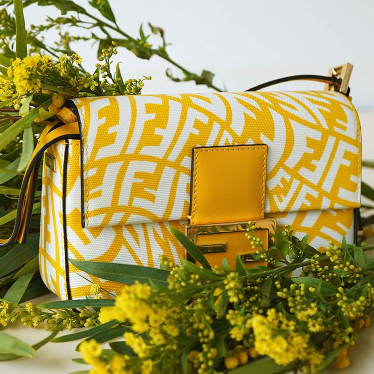 Yellow Fendi handbag with white FF logo pattern, surrounded by yellow flowers