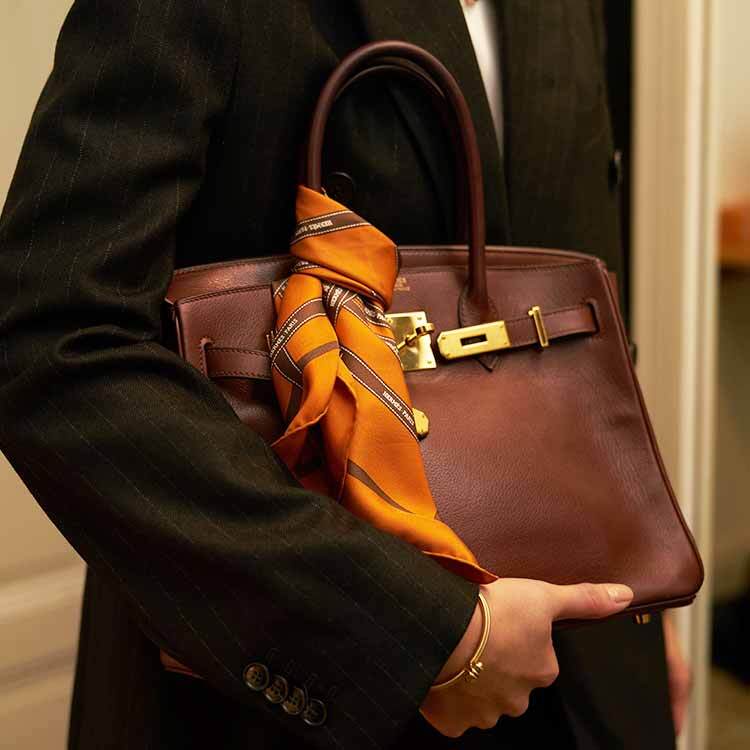 Birkin bag in Hermes orange on a cream white sofa