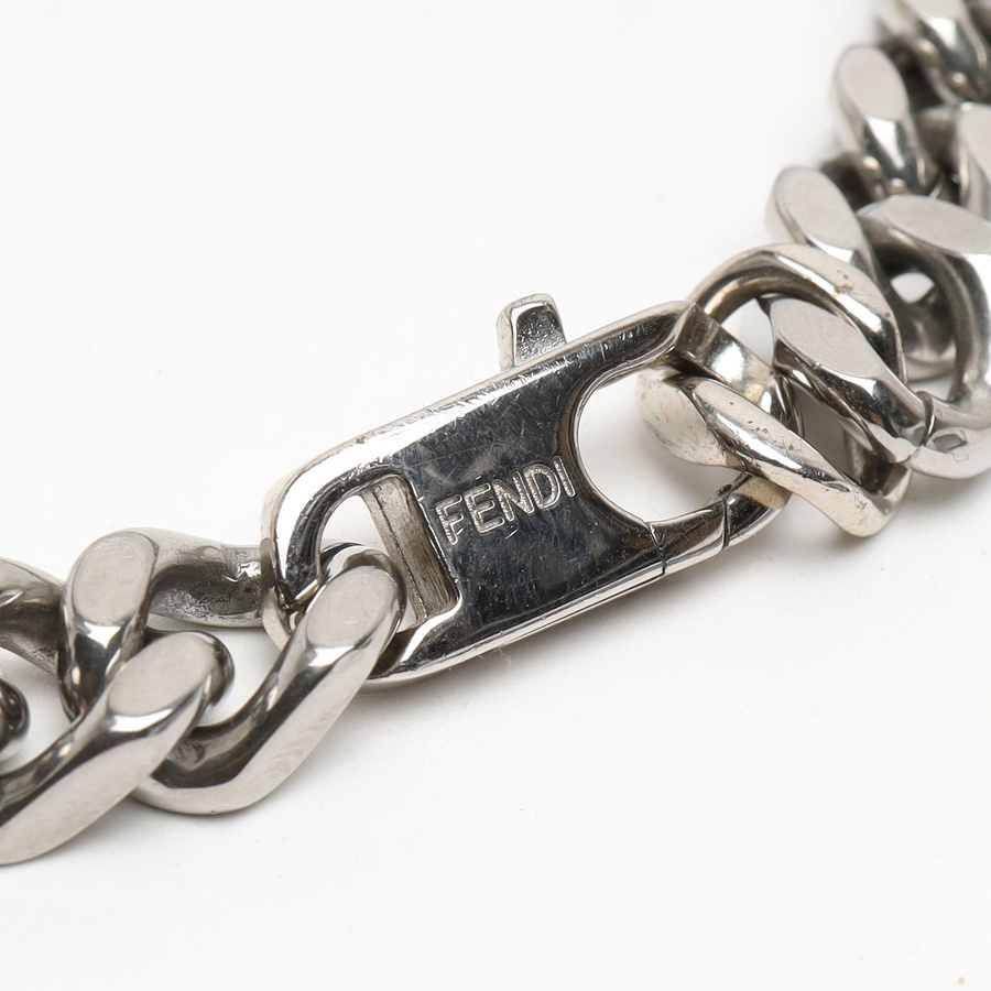 Close-up of the silver-tone FF logo detail on the vintage Fendi Baguette chain bracelet.