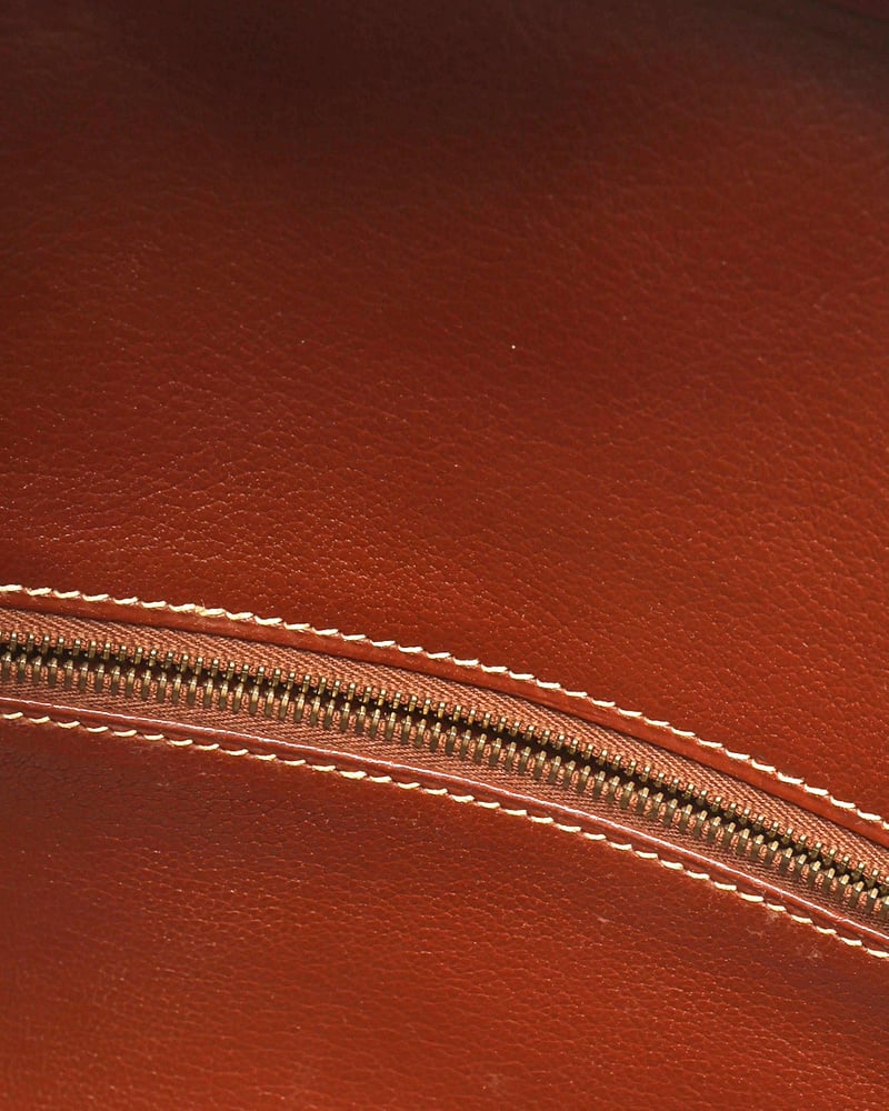 Detail shot of the internal zipper and contrast stitching on the brown leather lining of the Hermès Birkin 30 Courchevel bag.