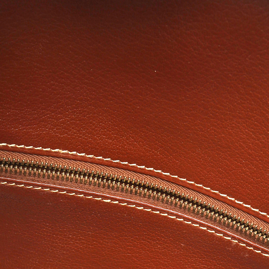Detail shot of the internal zipper and contrast stitching on the brown leather lining of the Hermès Birkin 30 Courchevel bag.