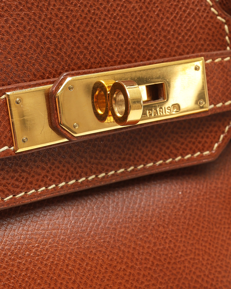 Close-up view of the gold-toned hardware and turn-lock closure on the brown Hermès Birkin 30 Courchevel Bag.