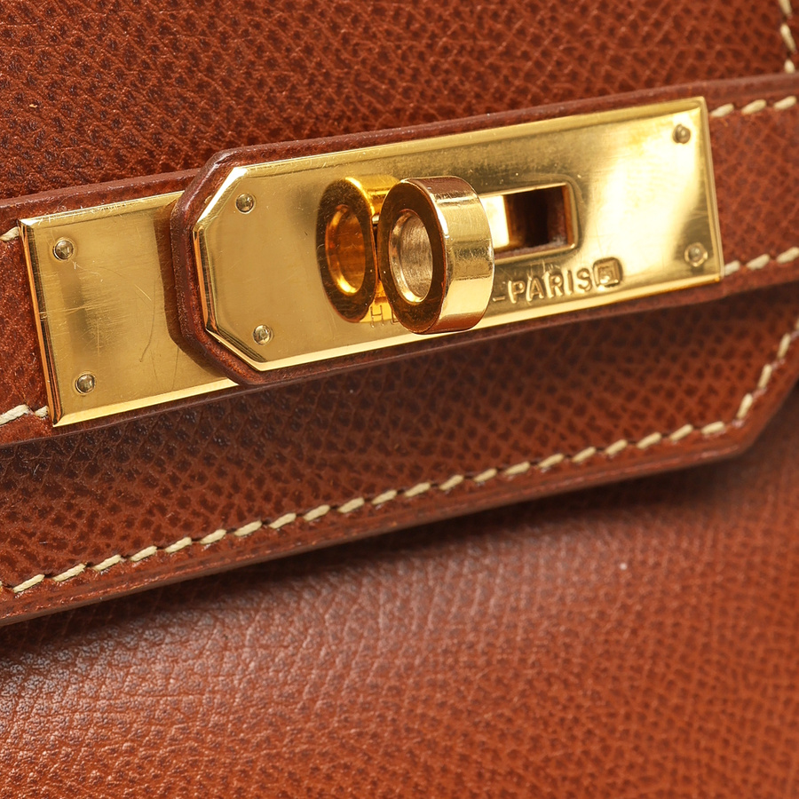 Close-up view of the gold-toned hardware and turn-lock closure on the brown Hermès Birkin 30 Courchevel Bag.