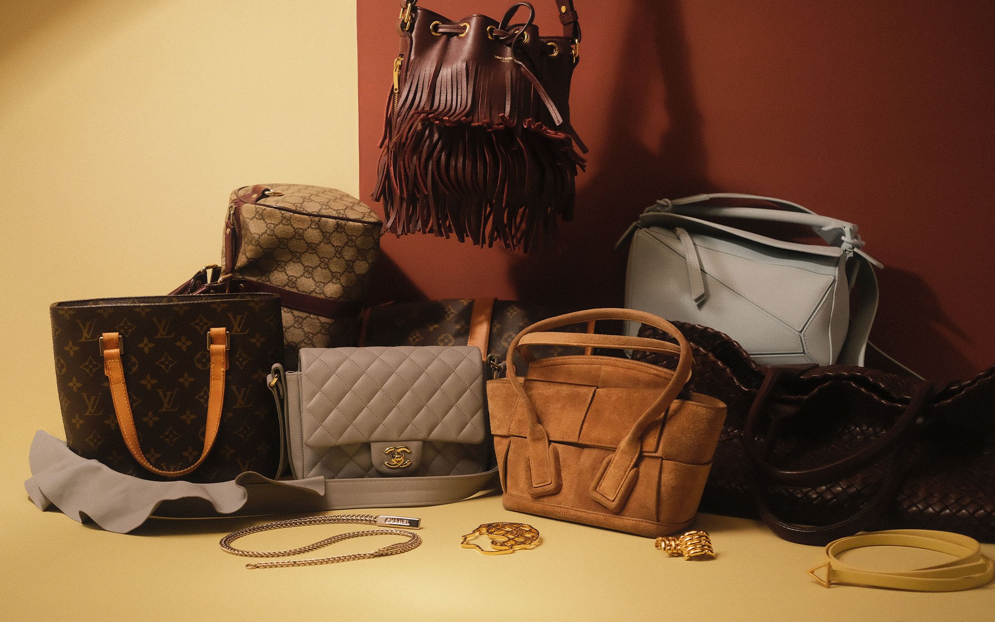 A person dressed in an elegant black outfit and veiled hat, accessorized with statement earrings and brooches. In the first view, they smile while holding a quilted black handbag with gold hardware. In the second view, they stand by a window, reaching toward the handbag resting on a stack of books.