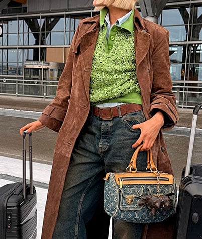 Person in white dress wearing a light blue quilted Chanel bag with silver chain over the shoulder.