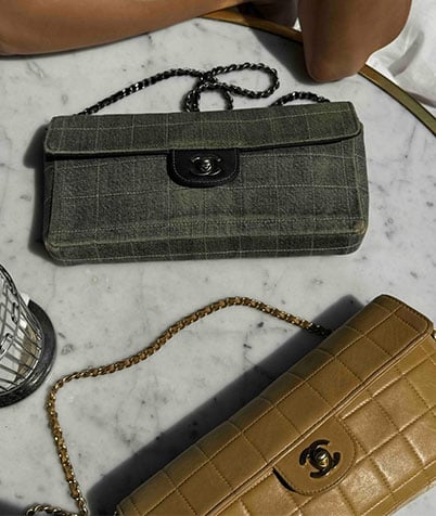 Two Chanel bags on a round marble table, one in green fabric and one in beige leather.